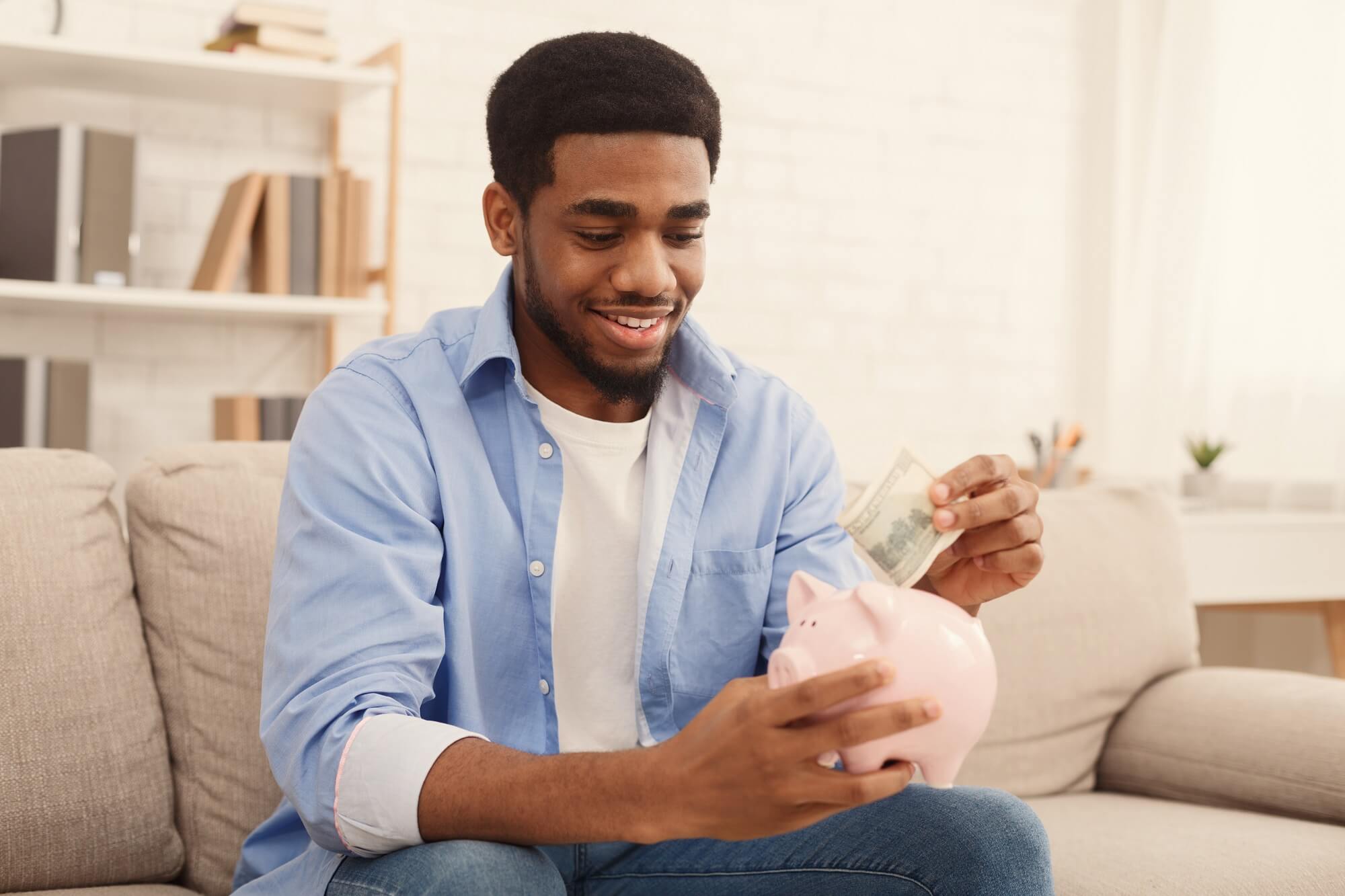 Personal investment, a man placing money into a piggy bank