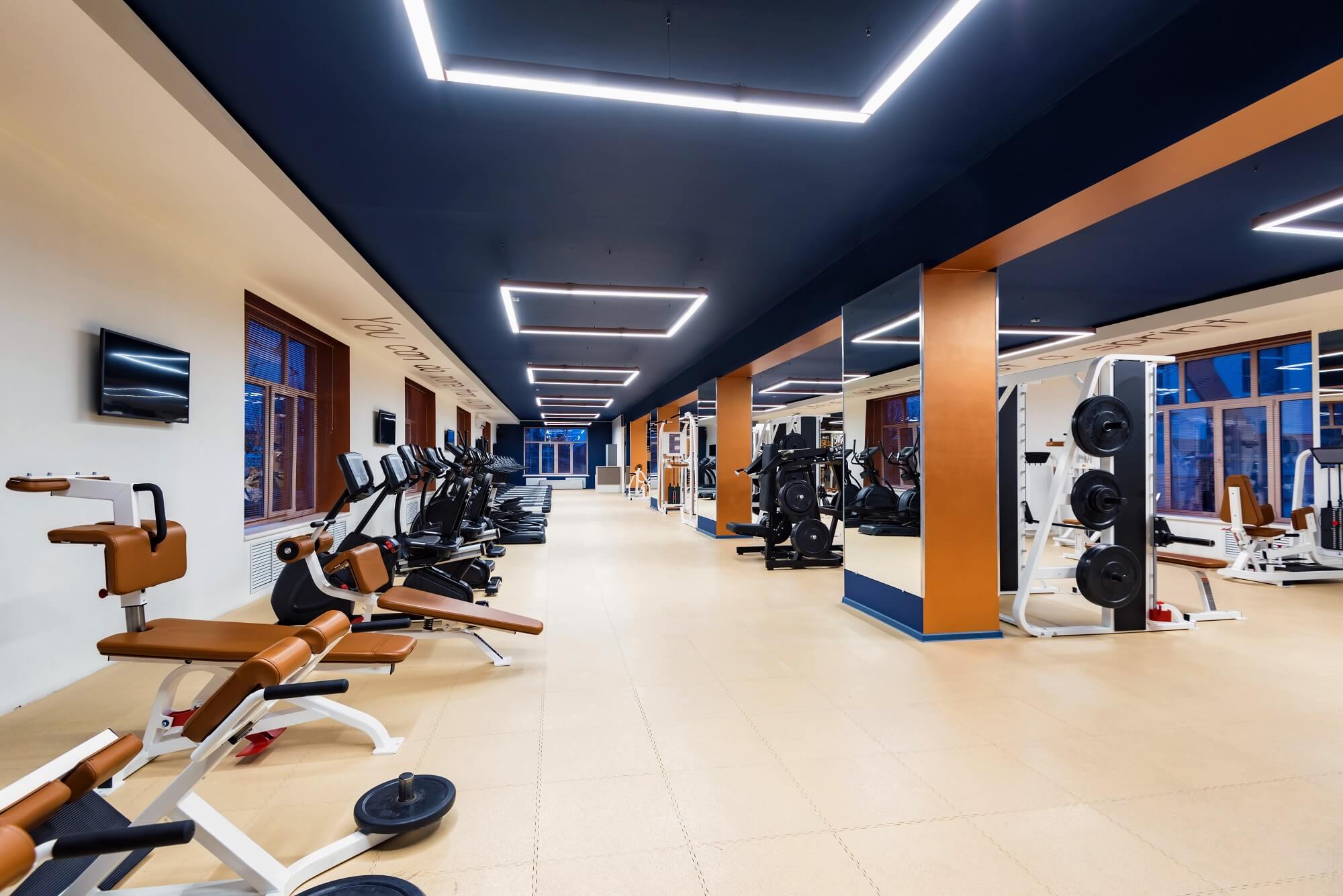 Interior with several modern fitness machines in gym