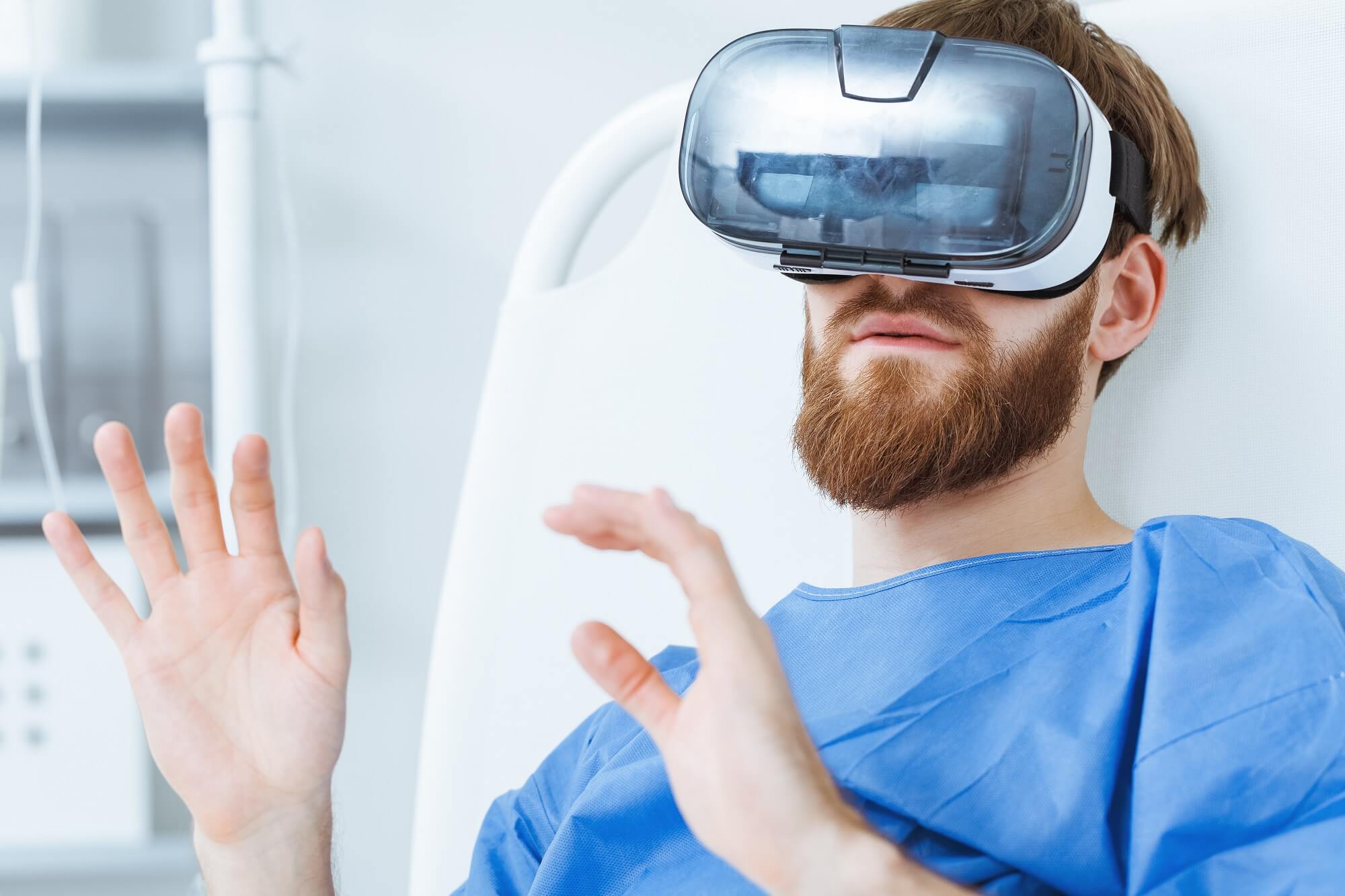 male bearded patient using VR goggles in hospital
