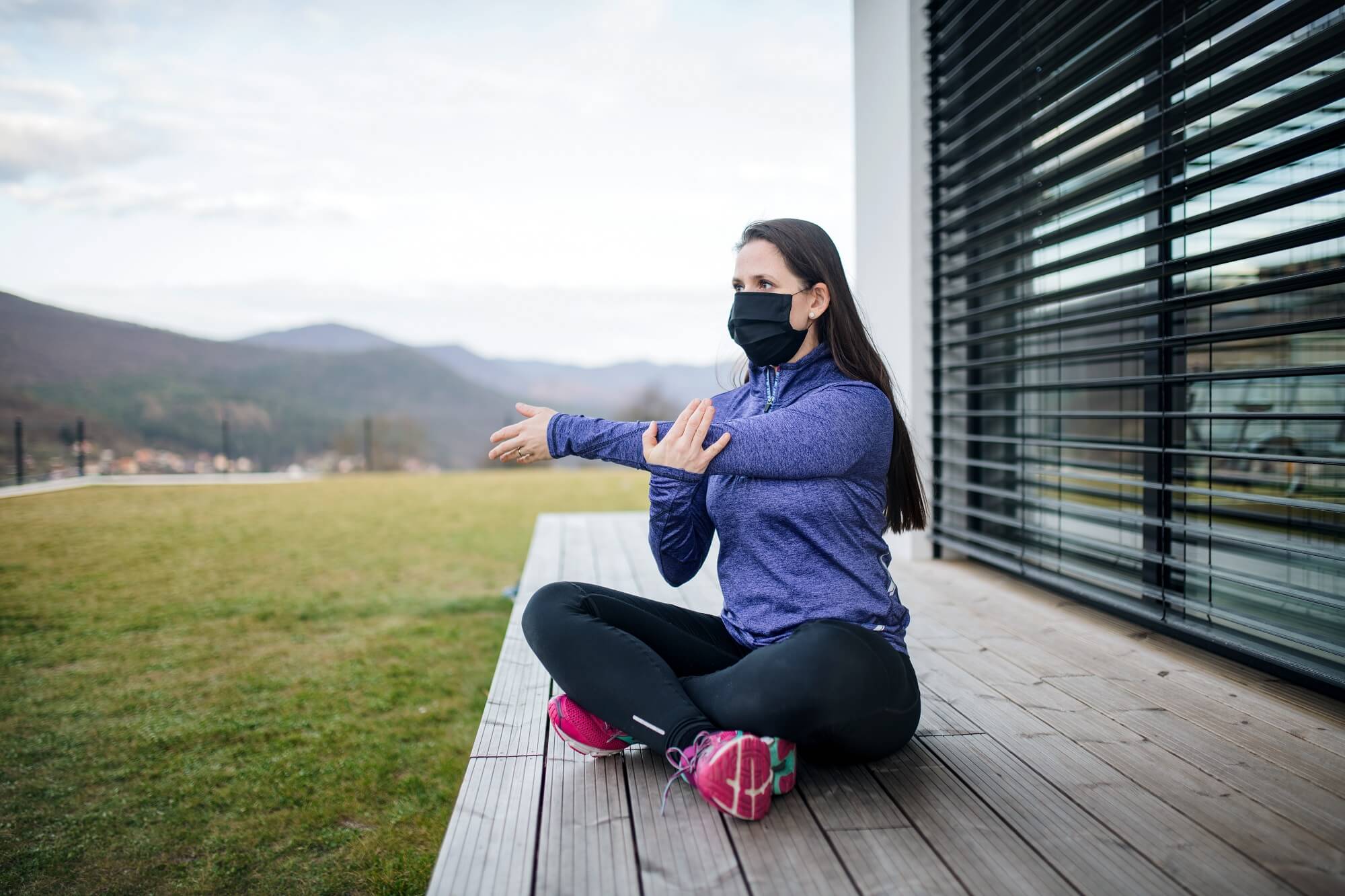 Woman with face masks doing exercise outdoors at home