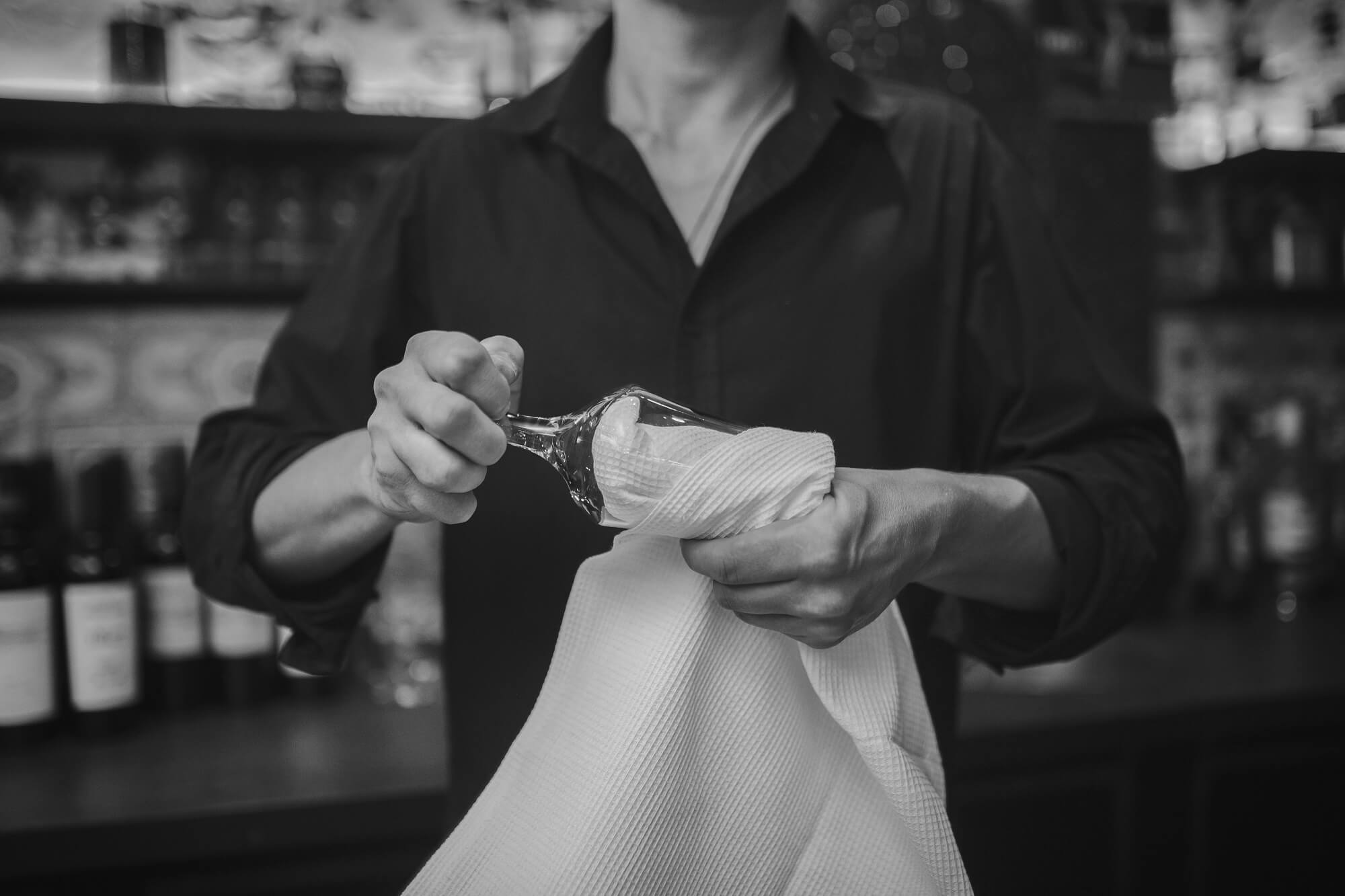 Barman at work in uk pub clean the glass after usage 