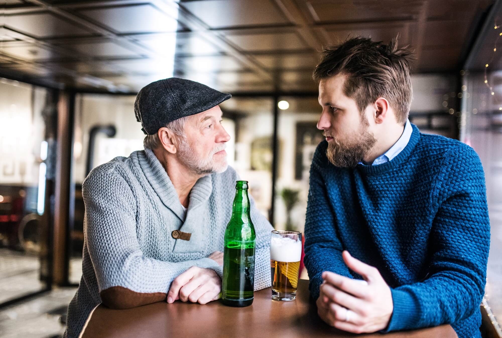 father and son drinking beer in a pub uk