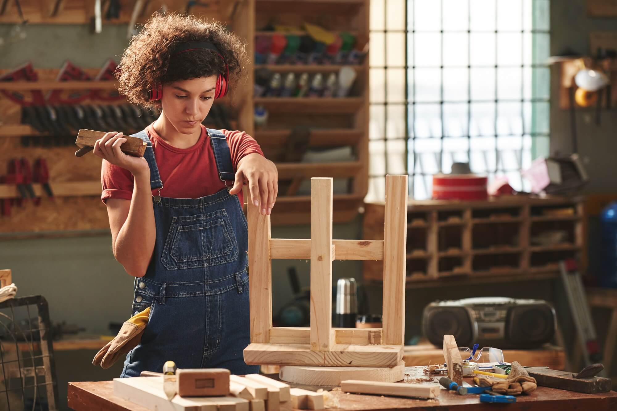 Female carpenter creating a chair 