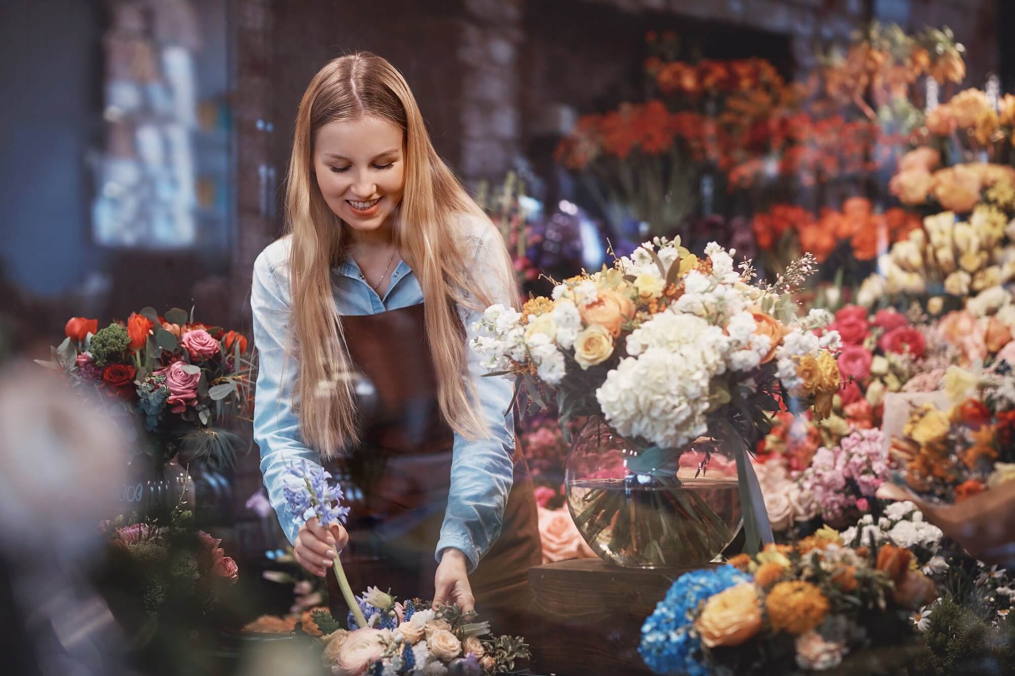 Young florist with flowers in the store
