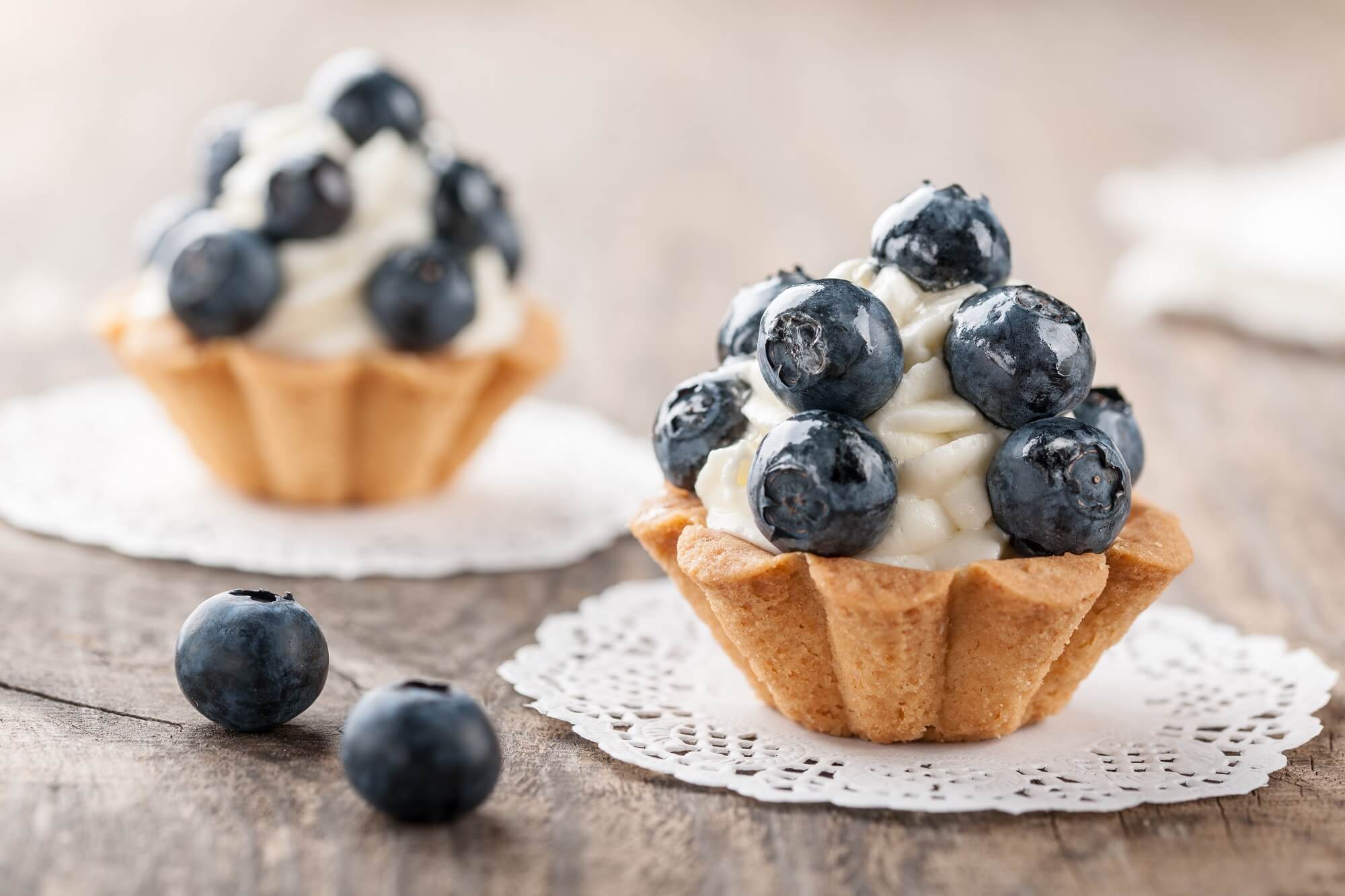 Cupcakes with blueberries on wooden table of an eggless cake shop