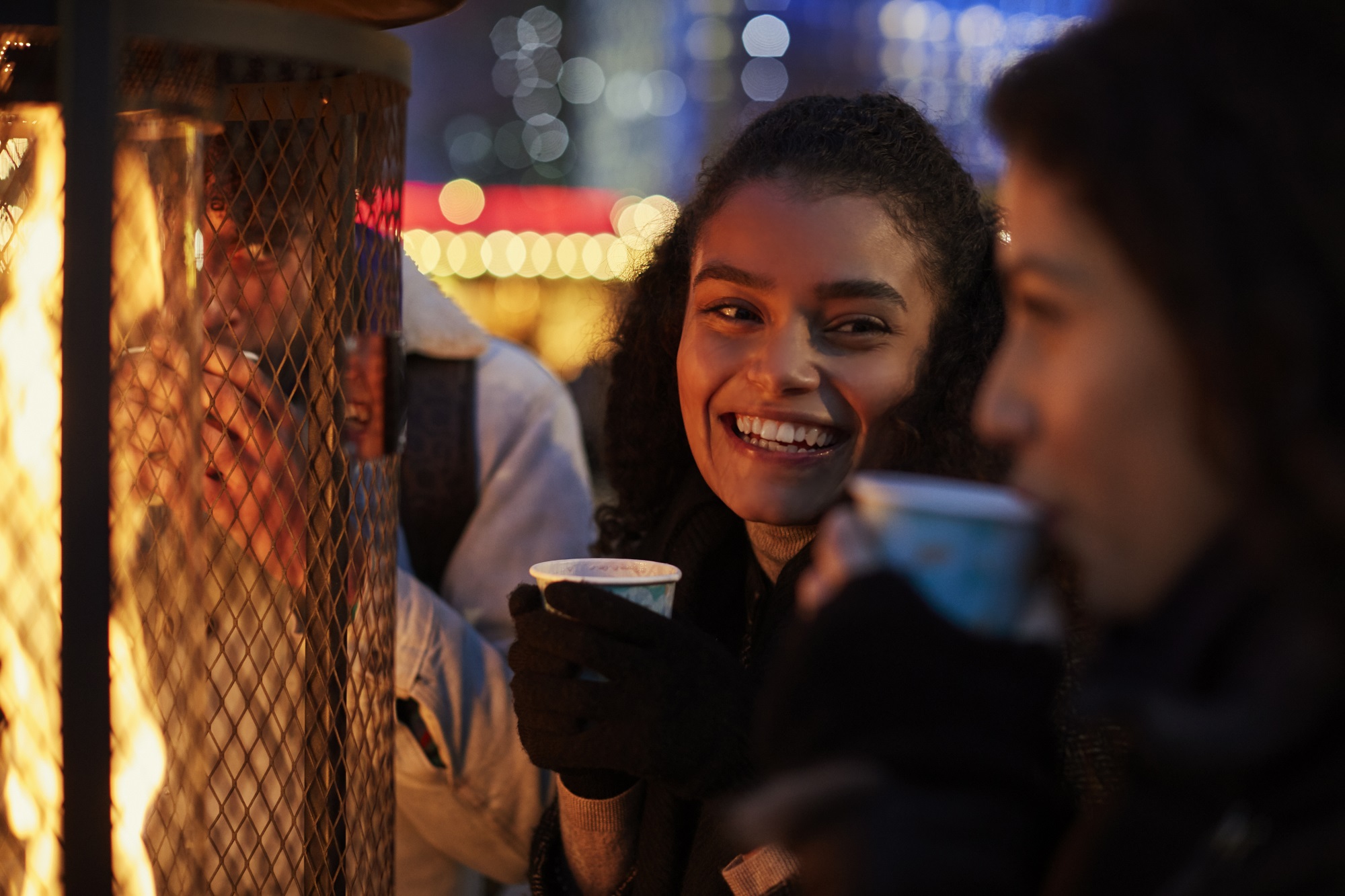 friends outside by fire lamp