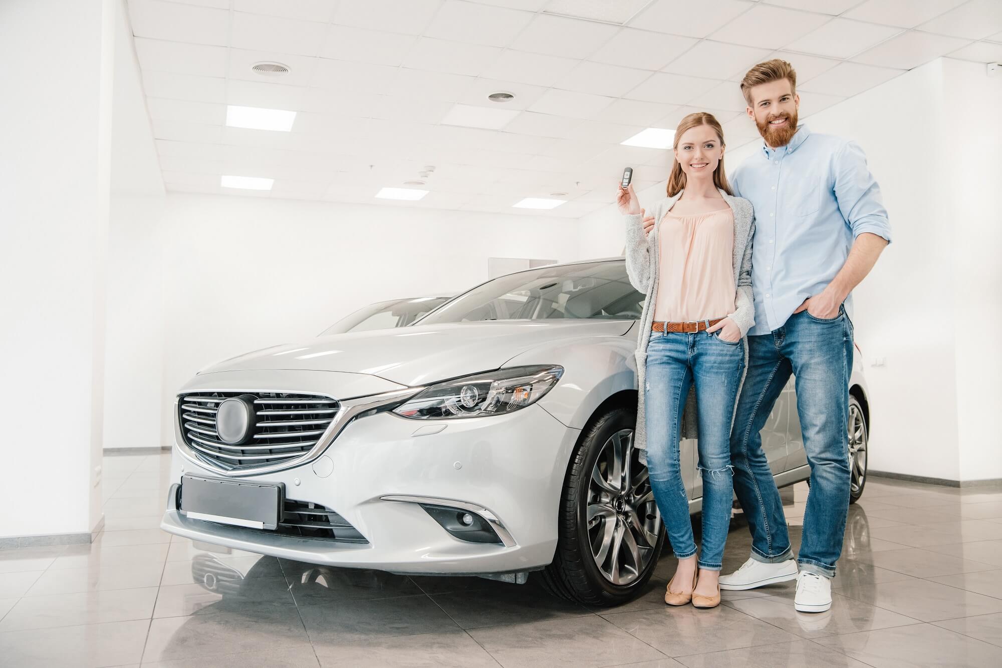 happy couple with keys to car rental 