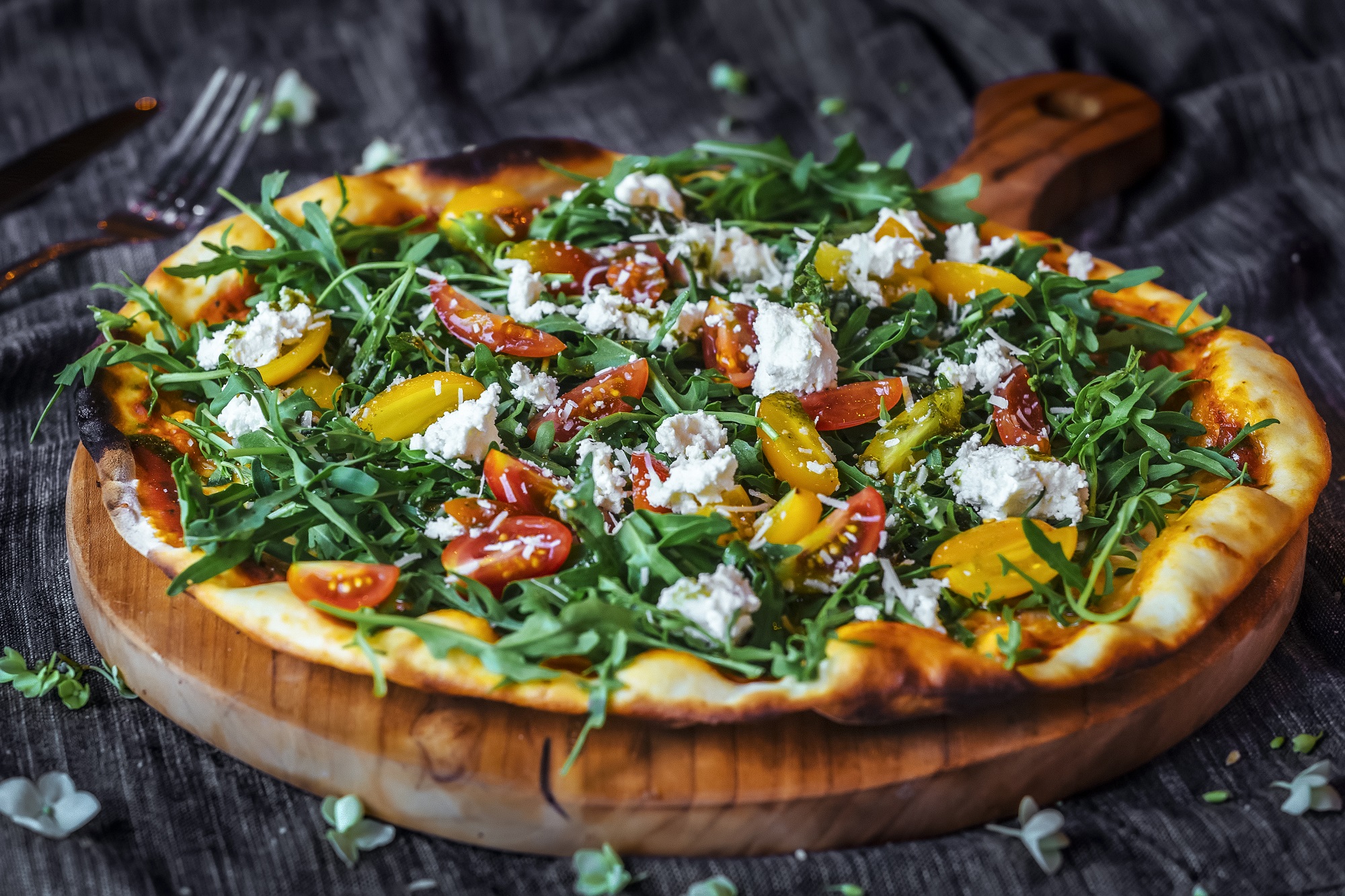 Pizza with tomatoes, feta cheese, salad and red onion for a healthy takeaway